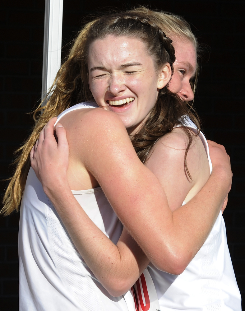Katherine Legatt-Barr of Greely, left, and teammate Carolyn Todd hug with joy after they finished first and second, respectively,  in the Division 1 portion of the Western Maine Conference championship meet at St. Joseph’s College in Standish. Legatt-Barr was timed in 19:19 and Todd in 19:44.