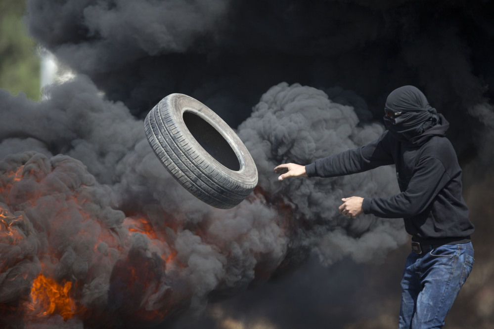 Palestinians burn tires during clashes with Israeli troops near Ramallah, West Bank, Friday. Tensions and violence have been mounting in recent weeks.