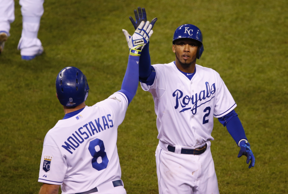 Royals shortstop Alcides Escobar, right, celebrates with third baseman Mike Moustakas after scoring on a double by first baseman Eric Hosmer in the eighth inning in Game 1 of the American League Championship Series against the Toronto Blue Jays on Friday in Kansas City, Mo.