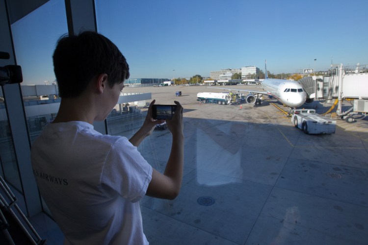 Ethan Hellofs, 13, of Chapel Hill, N.C. photographs the Airbus A-321 he will fly on to Charlotte, N.C., on Friday morning, at Philadelphia International Airport.