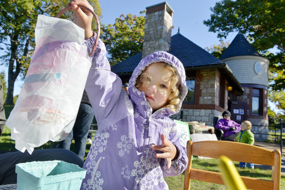 Three-year-old Celia Colson holds up a lantern that she and her father decorated Saturday in a workshop organized by the Friends of Deering Oaks in advance of a Lantern Walk set for Sunday. Celia and her parents, who live in Kansas City, Kan., are visiting Maine.