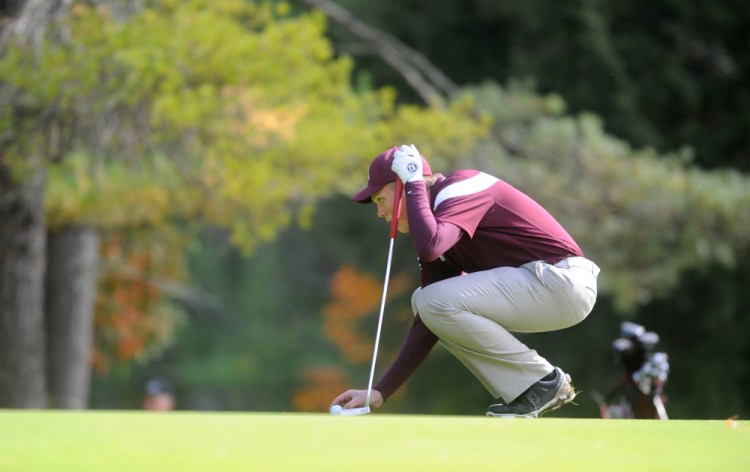 Maine Central Institute’s Eric Dugas places his ball on the green as he prepares to putt during the individual state championships Saturday at Natanis Golf Course in Vassalboro.