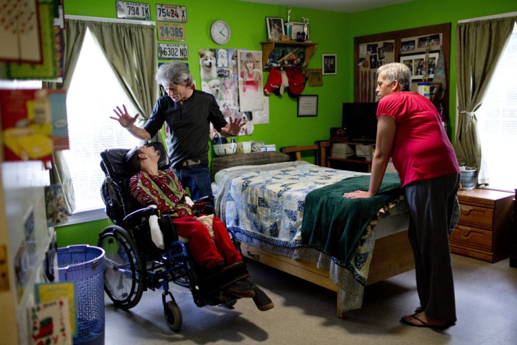 Dan McAllister, program manager at Residential Resources, a group home in Scarborough, talks with client Jerome Gonyer as he and aide Tammy Tapley provide personal care for him. McAllister says that if voters approve a $15 minimum wage on Election Day, it would make it difficult for him to keep his business afloat. 
Gabe Souza/Staff Photographer