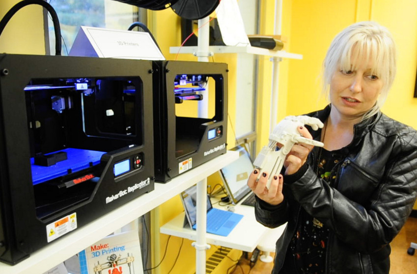 Staffer Becky LaBonte talks about a hand she built from parts made on a 3-D printer during an event on Thursday at the Maine State Library in Augusta.