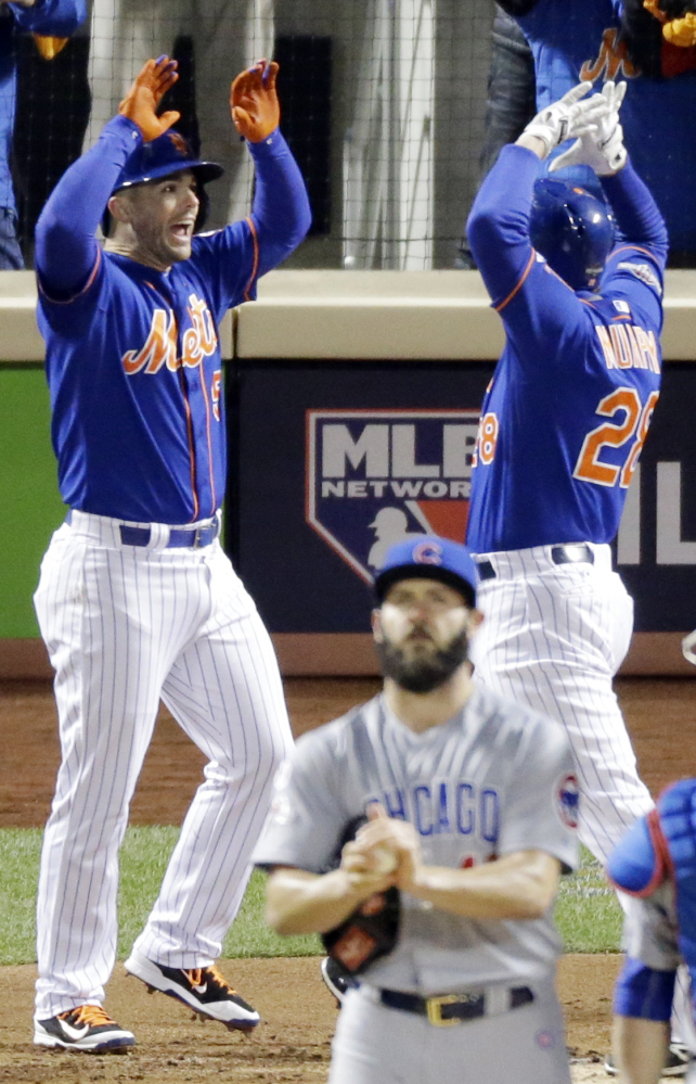 Daniel Murphy, right, is congratulated by David Wright after hitting a two-run homer off Cubs pitcher Jake Arrieta in the first inning of Game 2 of the NLCS Sunday in New York.