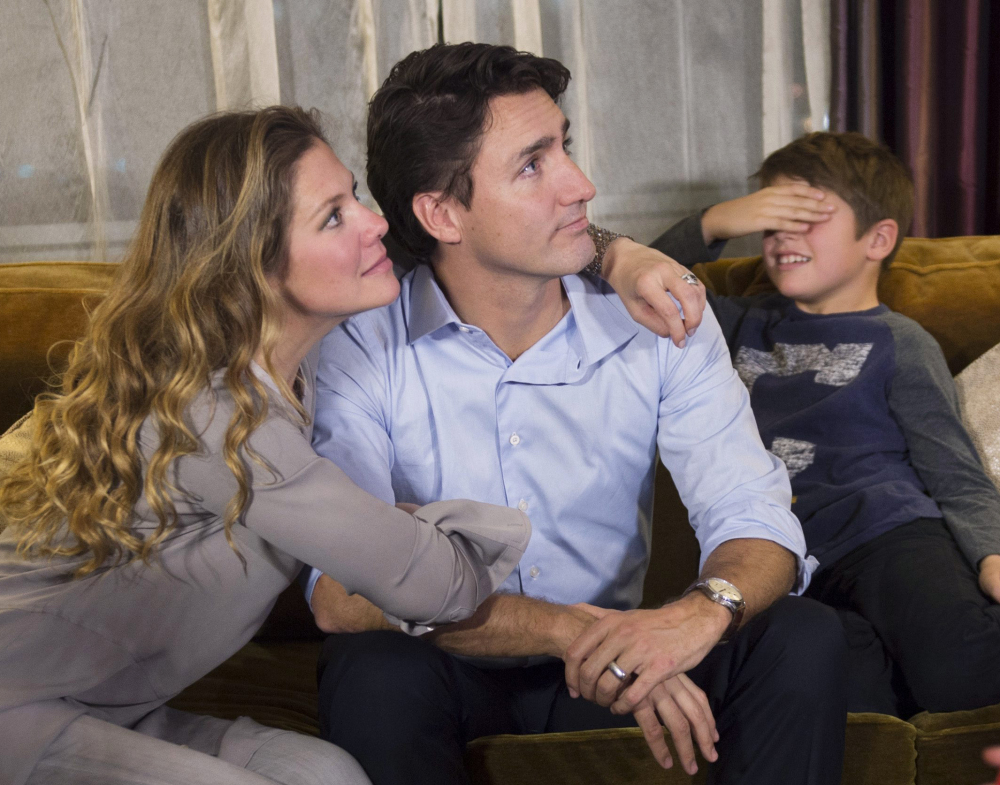 Xavier Trudeau, right, covers his eyes as his father, Liberal Party leader Justin Trudeau, watches the election results with his wife, Sophie Gregoire, at a hotel in downtown Montreal on Monday. Justin Trudeau is the son of the late Prime Minister Pierre Trudeau.