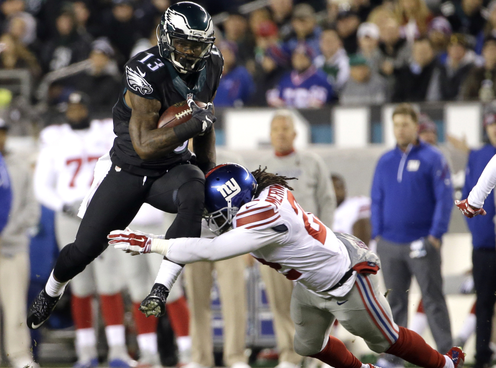 Philadelphia wide receiver Josh Huff, left, tries to avoid a hit by New York strong safety Brandon Meriweather during the first half of their game Monday in Philadelphia.