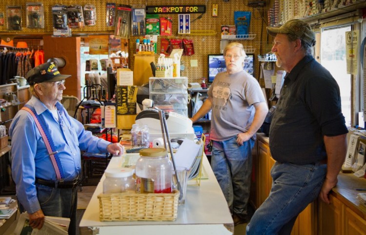 Shop co-owners Wayne Seidl, front right, and Joe Ruff, back right, talk with a customer at the Waite General Store. Residents of the small Washington County town of Waite, population 101, purchase more lottery tickets per capita than any other town in the state, according to lottery sales data.