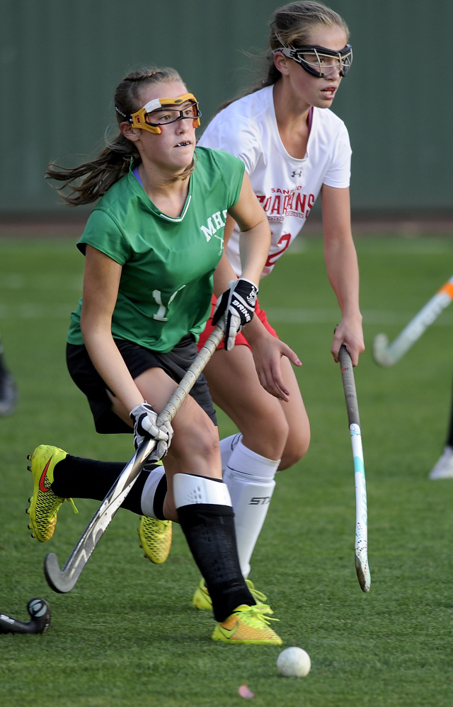 Emma Desrochers of Massabesic takes the ball down the field and looks for a teammate Tuesday while being shadowed by Bridget Duckworth of Sanford during Sanford’s 1-0 victory in the Class A South field hockey quarterfinals.
