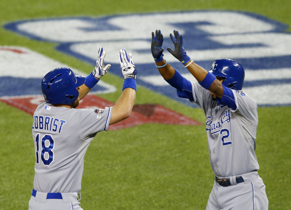 The Royals’ Ben Zobrist, left, celebrates his two-run home run with Alcides Escobar in the first inning of Tuesday’s American League Championship Series game in Toronto.