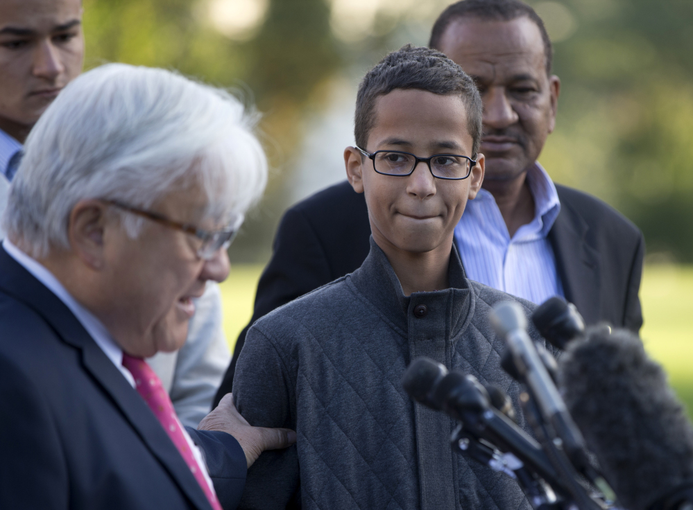 Ahmed Mohamed, second from right, listens as Rep. Mike Honda, D-Calif., left, speaks during a news conference on Capitol Hill in Washington on Tuesday. The Associated Press 