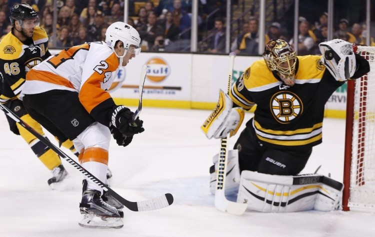 Bruins goalie Tuukka Rask stops the puck as the Flyers’ Matt Read comes in for a rebound during the first period of Wednesday night’s game in Boston. The Bruins built a 4-2 lead but gave it away in the third period.