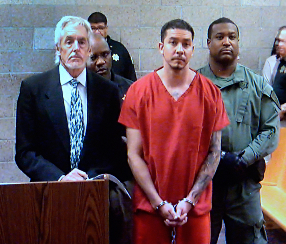 In this video frame grab provided by the Albuquerque Metro Court, Tony Torrez, center, stands with public defender Jeff Rein, left, while making an appearance Thursday in Albuquerque Metro Court via video. Torrez is charged with murder, assault, child abuse and other crimes in a road rage shooting that killed a 4-year-old girl.