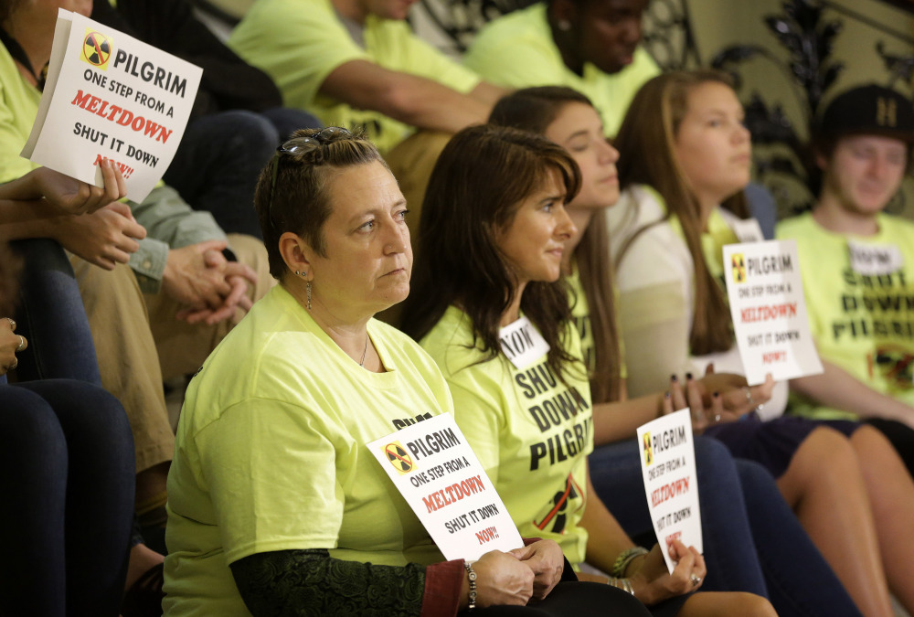 Massachusetts residents Kristin Knowles, bottom row left, and Laura Kelley, center, join others in calling for the closure of the Pilgrim nuclear plant at the Statehouse in Boston.