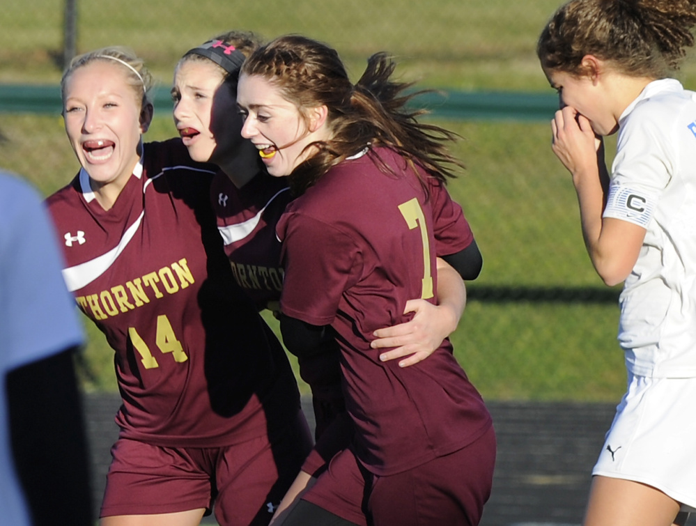Hannah Niles is sandwiched by Thornton Academy teammates Hannah McAlary, left, and Kerrigan Goudreau after scoring Friday in the 1-0 victory against Falmouth. Marcy Kittredge of the Yachtsmen walks away.