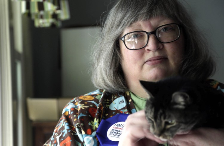 Gun-control activist Kim Yaman is seen with one her cats in her Cary, N.C. home. Yaman and her children survived a mass shooting at a university in 1991, and she became active in gun-control efforts after the Newtown shooting.