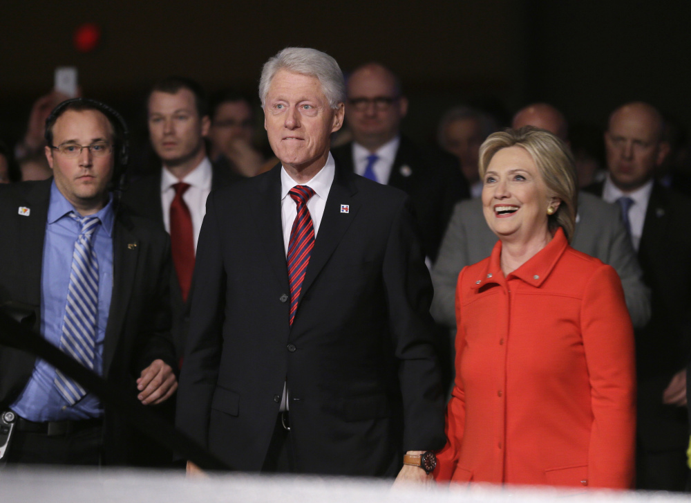 Former President Bill Clinton and his wife, Democratic presidential candidate Hillary Rodham Clinton, walk back to the stage after the Iowa Democratic Party’s Jefferson-Jackson fundraising dinner Saturday in Des Moines, Iowa.