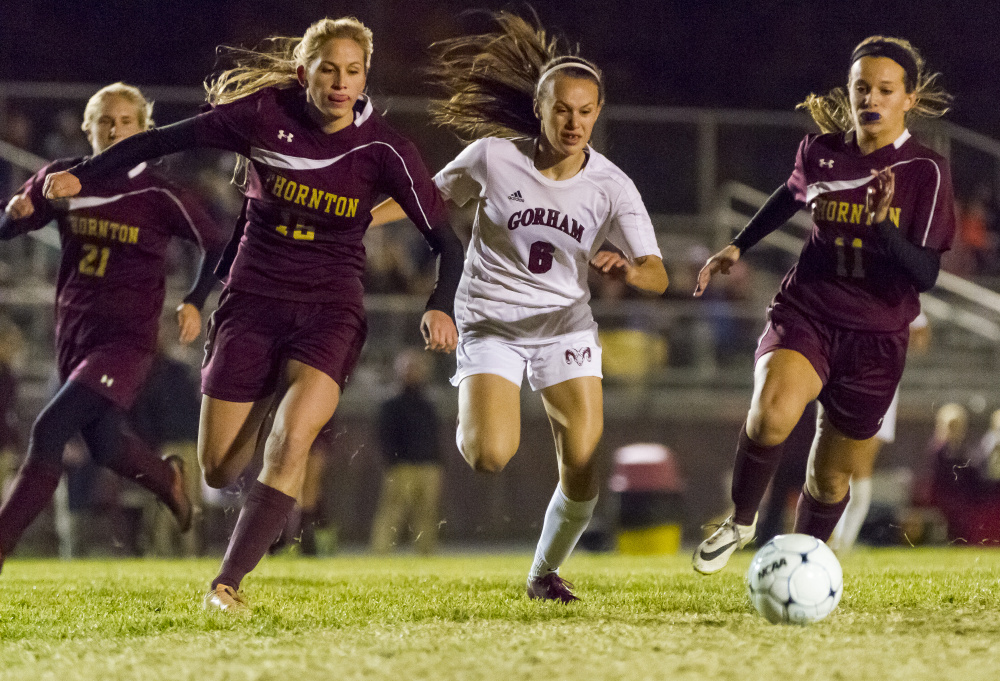 Thornton Academy defenders Cassidy Cochrane, left, and Tatum LeClair, right, race for the ball against Gorham sophomore Alexis Fotter during their quarterfinal game Tuesday at Gorham High School.