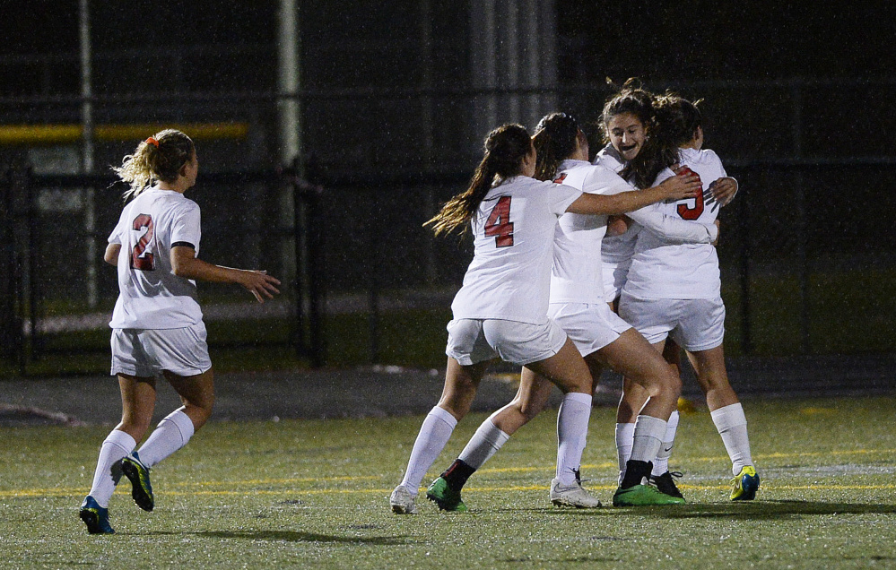 Teammates swarm to Scarborough’s Gaby Panagakos after she scored the game’s first goal Wednesday at Scarborough High. The Red Storm defeated Deering, 3-0. Shawn Patrick Ouellette/Staff Photographer