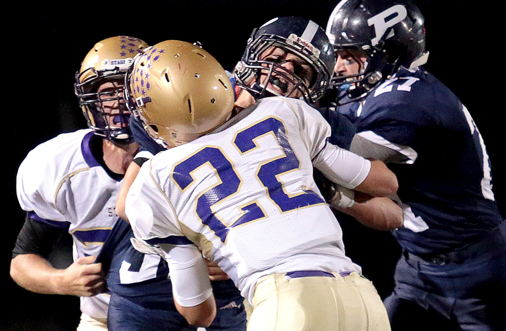 Joe Esposito of Portland was sandwiched between Isaac Dunn, left, and Justin Johnson of Cheverus early this month, but it didn’t happen often. He was second in rushing in Class A North and led in touchdowns.