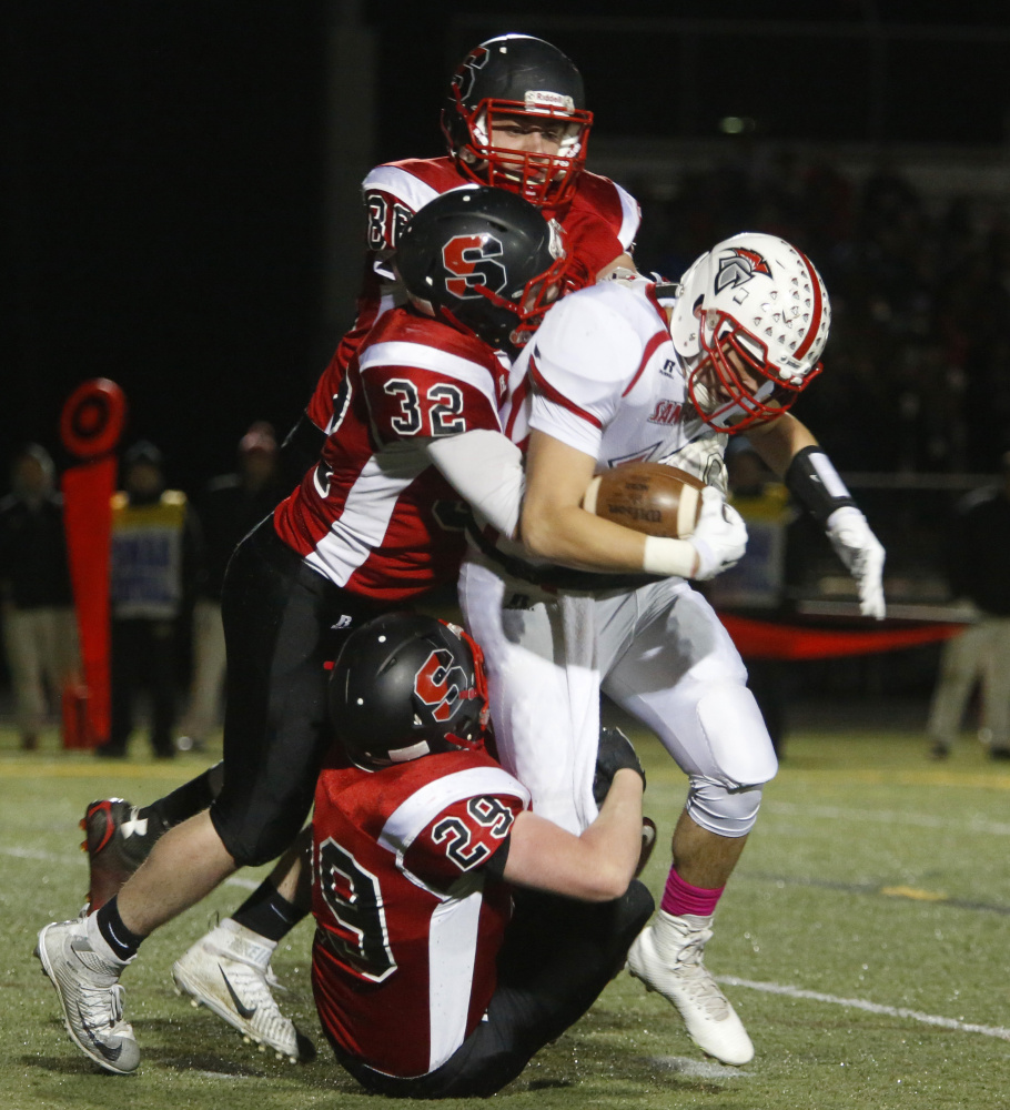 SCARBOROUGH, ME - OCTOBER 30: Sanford at Scarborough football quarterfinal. Frankie Veino of Sanford is caught for a loss as he is tackled by Scarborough defenders during the first quarter. (Photo by Derek Davis/Staff Photographer)