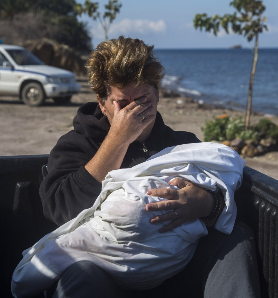 A local resident cries as she holds the body of a dead baby in Petra village on the northeastern Greek island of Lesbos on Friday.