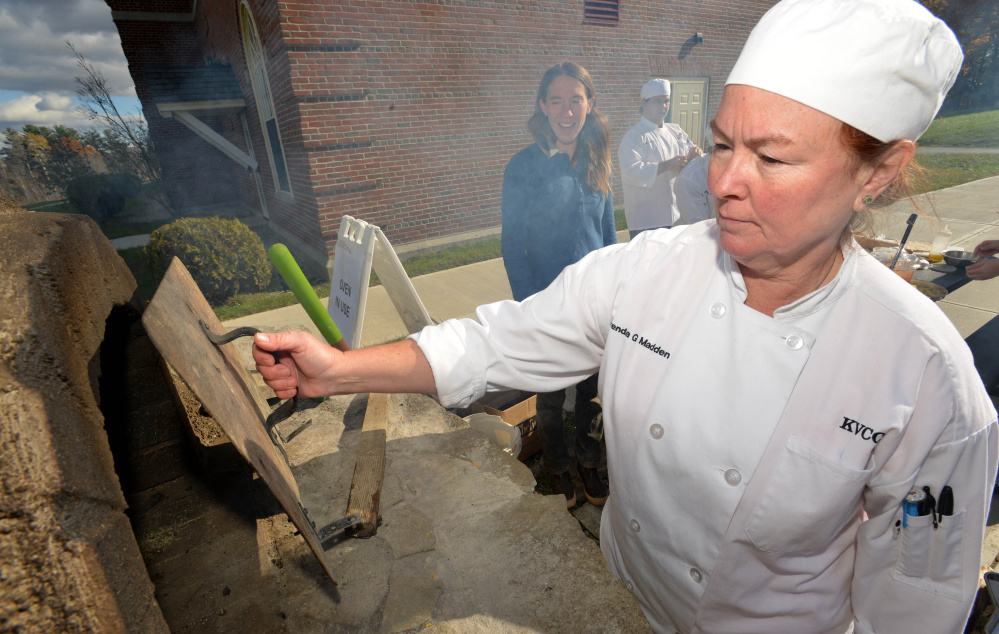 Brenda Madden checks on her calzone in the wood-fired oven during her culinary class at Kennebec Valley Community College on Friday.