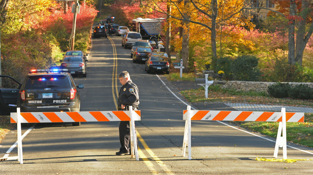 A road in the wealthy community of Weston., Conn., is blocked Friday, as state police search the area for evidence in the deaths of Jeanette and Jeffery Navin, parents of Kyle Navin.