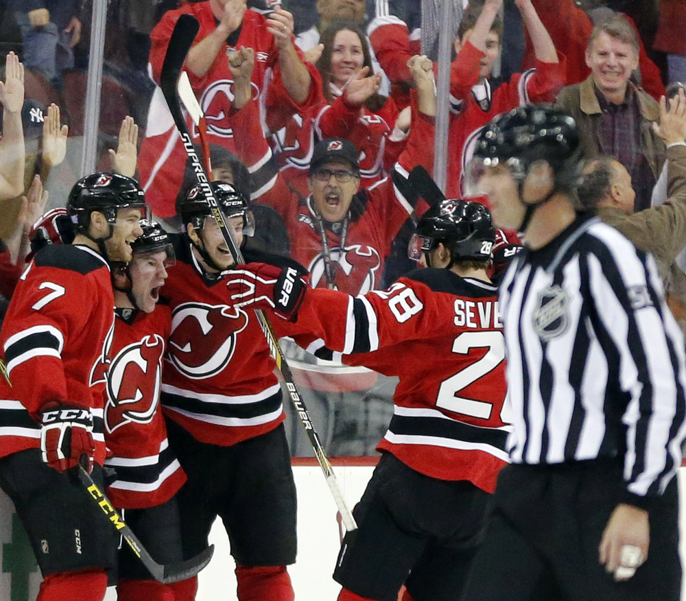 Bobby Farnham, second from left, is celebrates his first-period goal with Jon Merrill, left, Sergey Kalinin, center, and Damon Severson during the Devils 3-2 win over the Islanders on Saturday in Newark, New Jersey. The Devils won in a shootout.