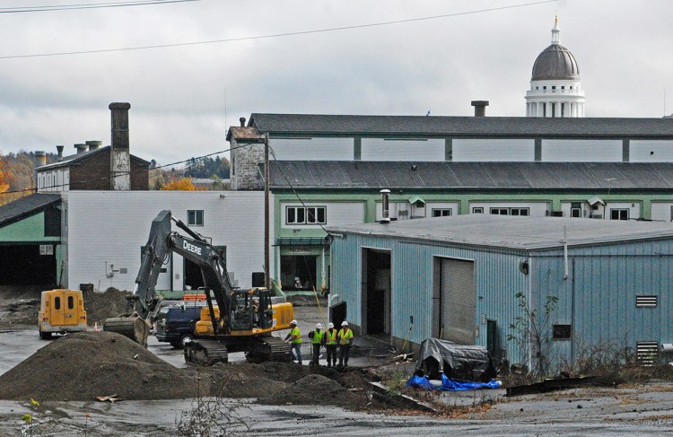 With the State House dome nearby, workers remove old underground fuel tanks from the former Maine Department of Transportation facility in Augusta on Thursday.
Joe Phelan/Kennebec Journal