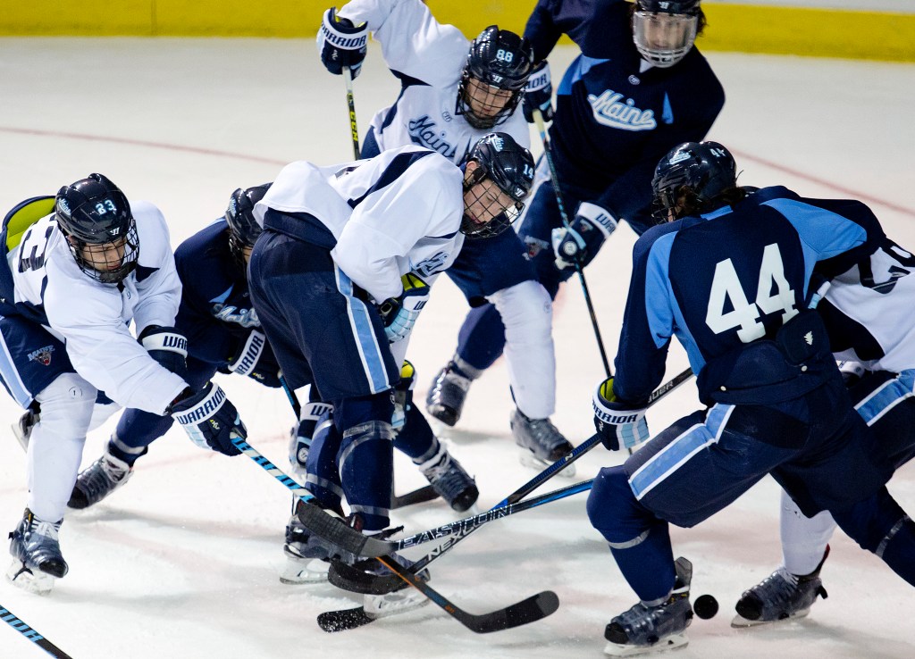 A scramble for the puck ensues at Maine’s practice, led by Sam Becker, left; Cedric Lacroix, center; Brian Morgan, center rear; and Conor Riley, right. The Black Bears are coming off three straight losing seasons. Gabe Souza/Staff Photographer