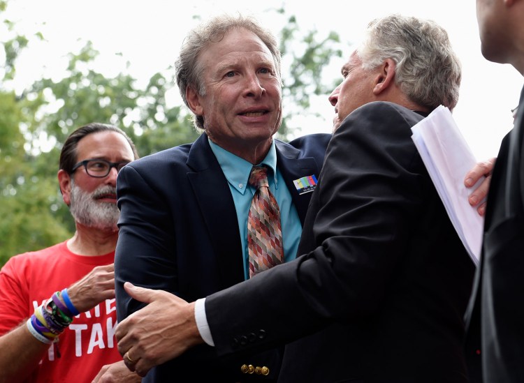 Andy Parker, father of WDBJ-TV reporter Alison Parker, who was shot dead on live television in Virginia on Aug. 26, center, gets a hug after speaking at a rally against gun violence in September in Washington. A letter writer points out that he, and others like him, are not driven by politics, but by grief. 