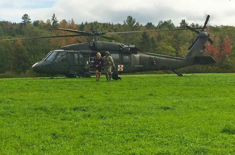 Gabrielle Grace is helped away from the rescue helicopter by a crew member. Courtesy Maine Warden Service