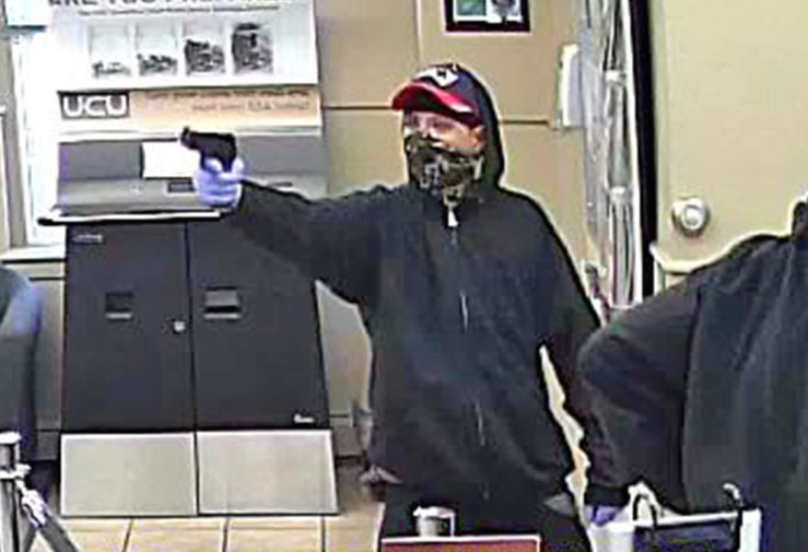 This image from surveillance video shows a robber pointing a gun at the University Credit Union at 391 Forest Ave. in Portland on Sept. 4. A New Hampshire woman has been charged. 