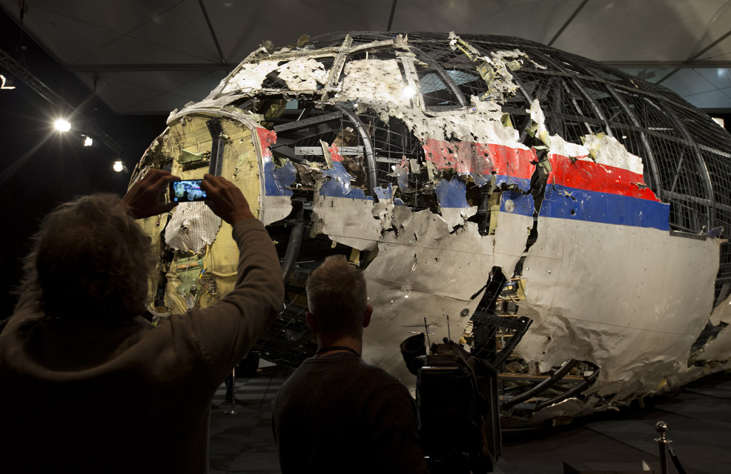 Journalists take images of part of the reconstructed forward section of the fuselage after the presentation of the Dutch Safety Board's final report. The Associated Press