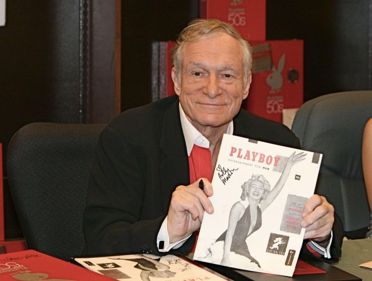 Hugh Hefner signs copies of a Playboy calendar and DVD box set in this 2007 photo. Playboy will stop publishing nude photos with its March 2016 issue. The Associated Press
