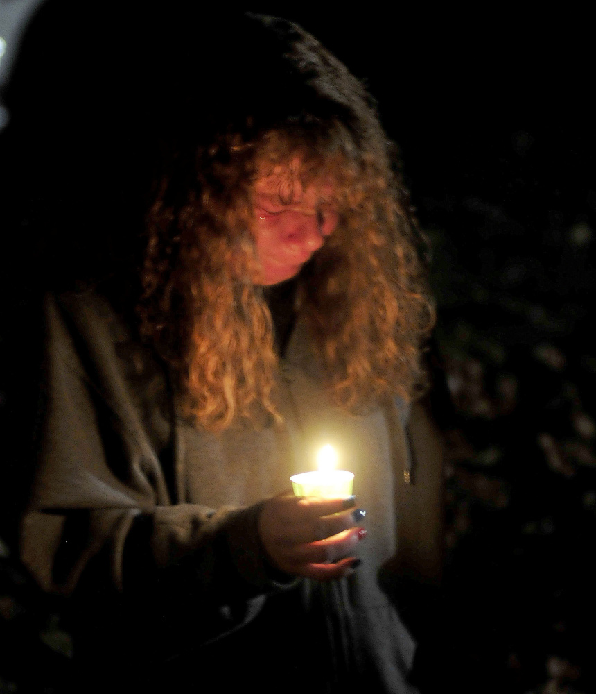 Theresa Tibbetts wept during a candlelight vigil at the boat landing on Sunday for victims of the murders in Oakland last week. “This has been real hard on me,” Tibbetts said.