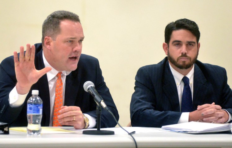 Gregg Frame, left, attorney for Waterville Senior High School principal Don Reiter, right, responds on Tuesday to allegations that his client engaged in inappropriate conduct with a student in August.  The exchange occurred during a public hearing at George J. Mitchell School in Waterville. 
