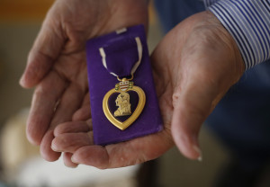 John Whitney holds the Purple Heart given in honor of his older brother, Pfc. Thomas Whitney, who disappeared during World War II. Derek Davis/Staff Photographer