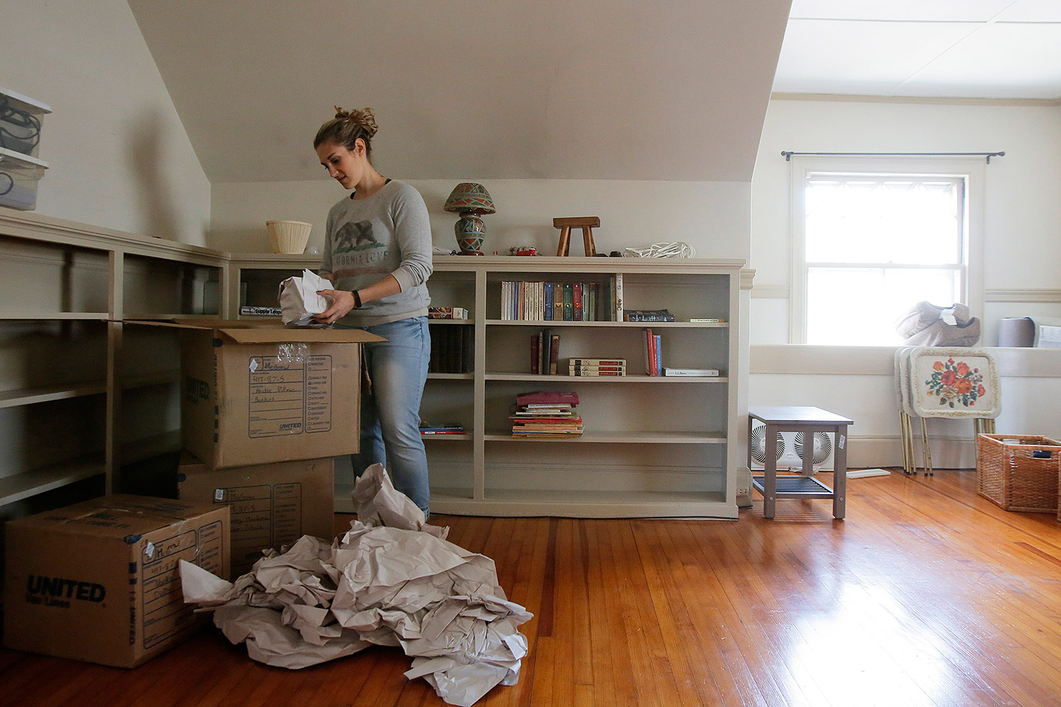 Ivy McGrew unpacks boxes in her new apartment in Portland's West End.