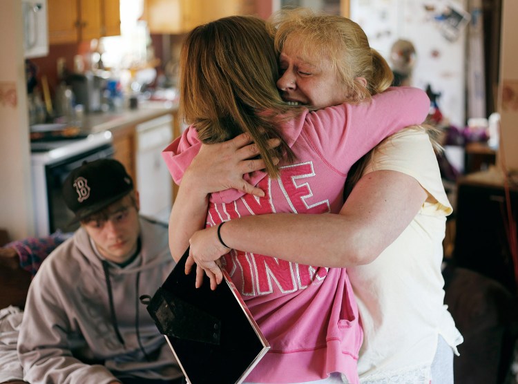 Christa Greene, whose daughter, Angel Greene, was killed in a car crash early Thursday morning, hugs family friend Ansley Moore at her home in Standish. At left, is Angel's boyfriend, Nathan Buzyniski, 19, of Dayton. 