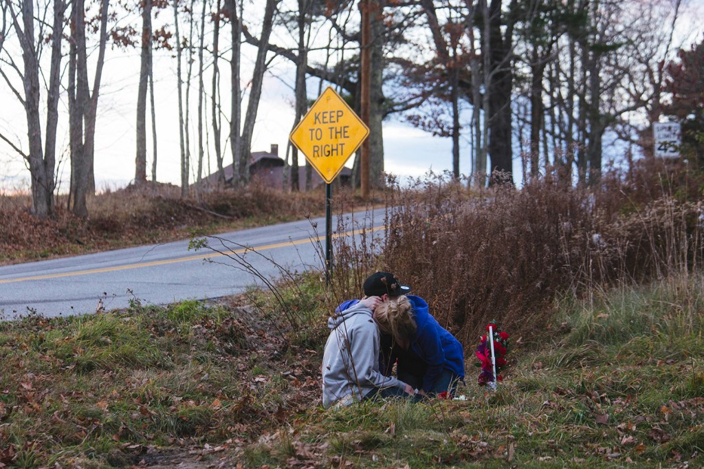 Kara Buzynski holds her brother, Nate Buzynski, after they placed flowers on a memorial for Angel Greene, who was killed in a car accident on Turkey Lane in Buxton on Thursday.