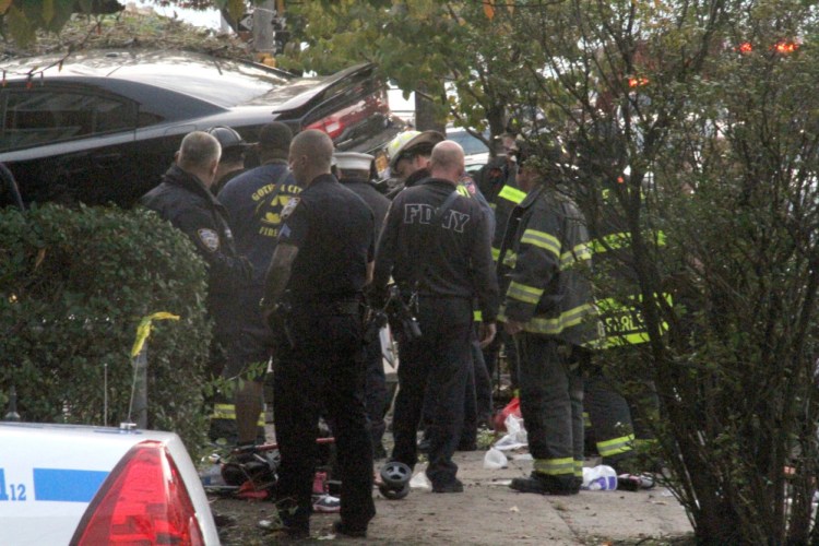 First responders examine a  car after its driver lost control and plowed into a group of trick-or-treaters Saturday in New York.