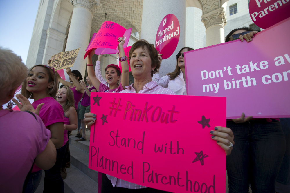 Activists rally in support of Planned Parenthood on “National Pink Out Day” in Los Angeles on Sept. 29. A push to cut off public funding to the organization continues although multiple states have cleared Planned Parenthood of having broken any laws.