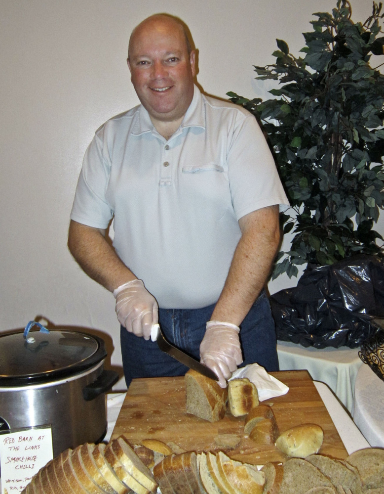 SoBo Central volunteer Mike Moloney slices bread for last year’s Soup Supper to raise funds for Keep South Berwick Warm.