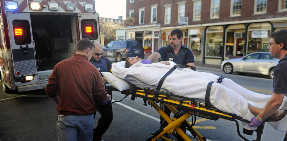 Medics wheel a man into an ambulance on Water Street in Hallowell on Monday. The man said he was stabbed at Hallowell Cemetery.