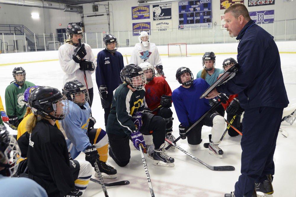Cheverus girls’ hockey coach Kent Hulst talks to his players during practice Monday in Portland at the same arena he practiced at as a Pirate.