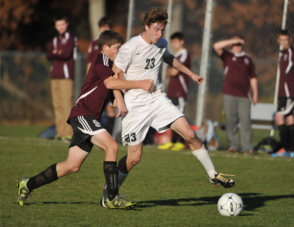Waynflete’s Tommy Silk, right, holds off Monmouth defender Dylan Goff during the Class C regional final on Wednesday.