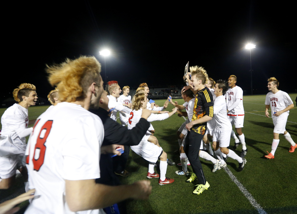 Scarborough teammates celebrate after defeating Cheverus 2-0 in the Class A South regional soccer final on Wednesday.  Derek Davis/Staff Photographer