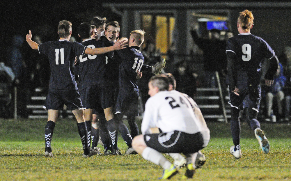 Yarmouth players celebrate after knocking off top-seeded Maranacook 3-2 in double overtime in the Class B South championship game on Wednesday in Readfield.